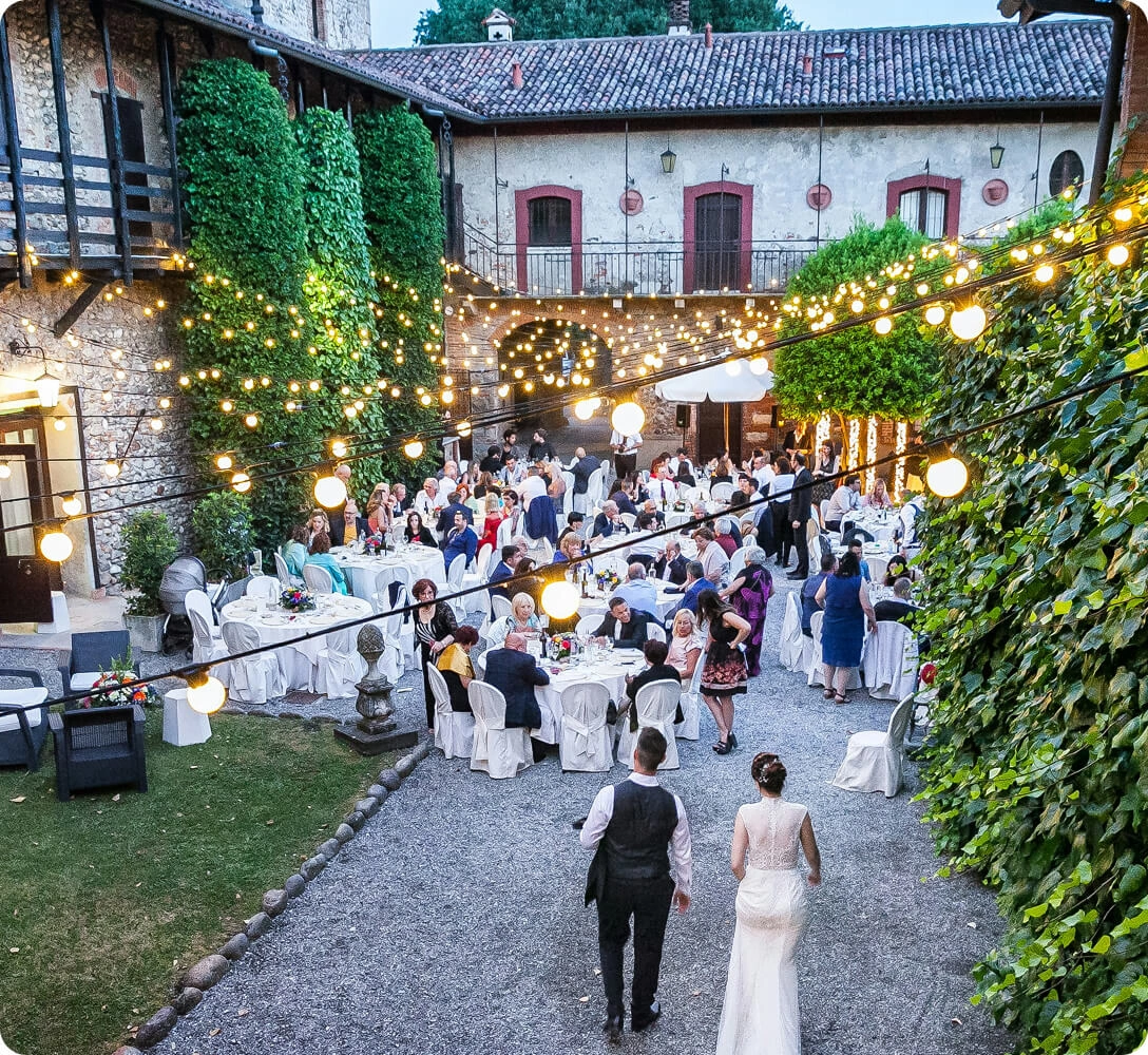 Wedding reception tables set for guests under string lights