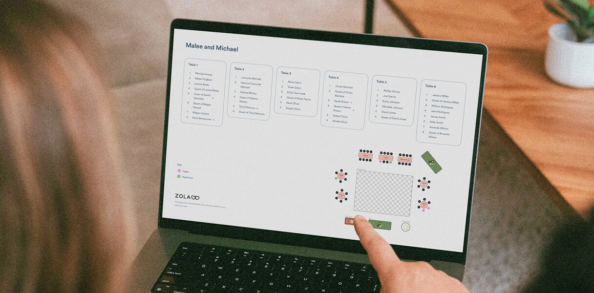 Laptop showing a downloadable Zola wedding seating chart PDF