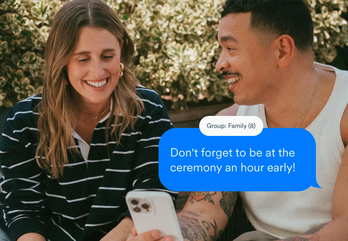 A man and a woman sending a message to their wedding guests using the Zola iOS app