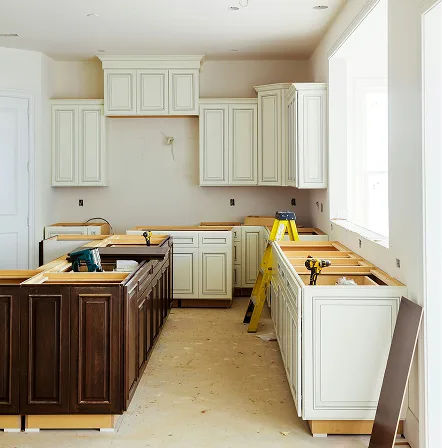 A kitchen mid-renovation with cabinets partly installed and the subfloor exposed