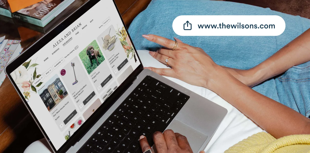 A laptop showing a couple’s Zola wedding website alongside their custom URL, www.thewilsons.com